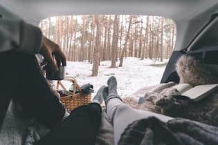 5 winterliche Wohlfühl-Hacks aus Schweden Personal perspective of a couple on a cozy picnic in the trunk of a car during winter.