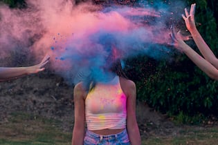 Wie lässt man erwachsene Kinder los? Two Young woman Throwing Holi Powder at To their friend