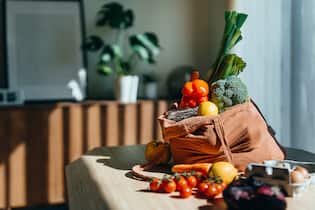 Fünf Superfoods mit überraschend grosser Wirkung Eco-friendly reusable shopping bag with multi-coloured fresh vegetables and groceries on the table at home. Shopping with reusable grocery bag for plastic free and waste-free life. Responsible shopping. Zero waste and sustainable lifestyle concept