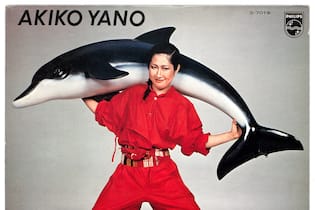 Diese Ausstellungen gibt es im März zu entdecken an asian woman in a red overall shouldering a fake dolphin