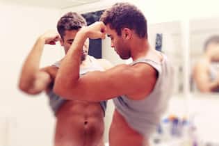 Diese Sucht führt vom Gym direkt in die Zwangsstörung Young adult/teen guy examining his body reflection in the bathroom mirror with a neutral expression can be used to convey youth health or self image, or vanity.