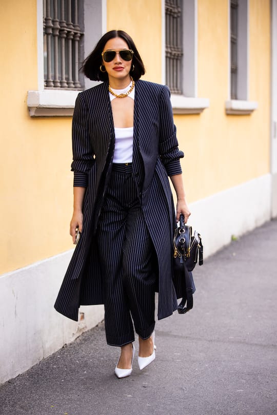 MILAN, ITALY - FEBRUARY 21: Tiffany Hsu, wearing a white top, blue striped long blazer with matching pants, white heels and black bag, is seen outside Tod's show, during Milan Fashion Week Fall/Winter 2020-2021 on February 21, 2020 in Milan, Italy. (Photo by Claudio Lavenia/Getty Images)