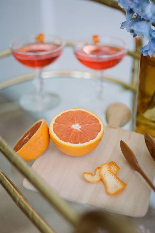 cocktail party close up of bar cart orange peel cut open with drinks in the background