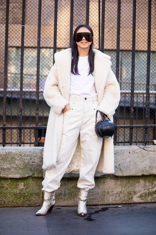 PARIS, FRANCE - FEBRUARY 27: A guest, wearing a white t-shirt, white jeans, snake print boots, black bag, black sunglasses and white fur coat, is seen outside Lanvin on Day 3 Paris Fashion Week Autumn/Winter 2019/20 on February 27, 2019 in Paris, France. (Photo by Claudio Lavenia/Getty Images)