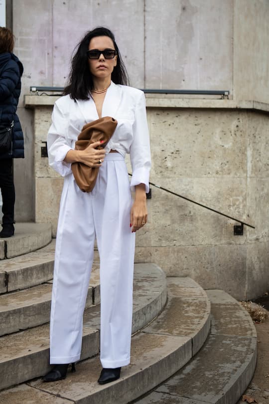 PARIS, FRANCE - MARCH 04: Evangelie Smyrniotaki, wearing a white shirt, white pants, black heels and beige bag, is seen outside Sacai on Day 8 Paris Fashion Week Autumn/Winter 2019/20 on March 4, 2019 in Paris, France. (Photo by Claudio Lavenia/Getty Images)