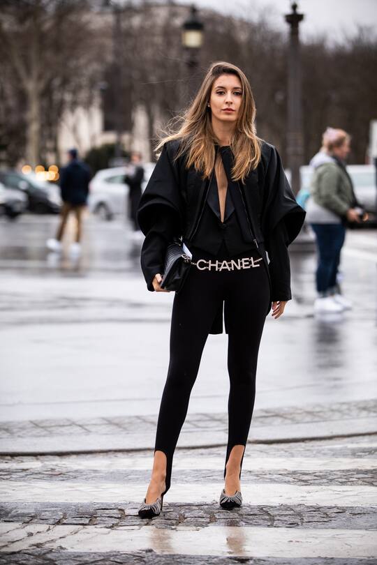 PARIS, FRANCE - MARCH 05: A guest, wearing a black top, black leggings, Chanel belt, silver and black heels, black bag and black jacket, is seen outside Chanel on Day 9 Paris Fashion Week Autumn/Winter 2019/20 on March 5, 2019 in Paris, France. (Photo by Claudio Lavenia/Getty Images)