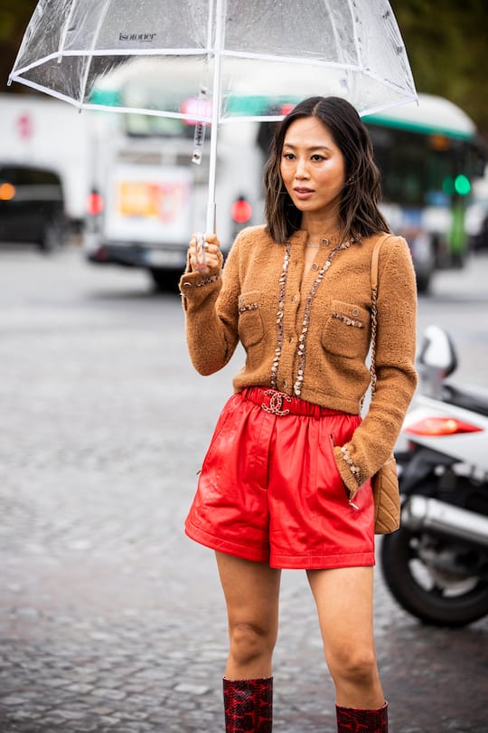 PARIS, FRANCE - OCTOBER 01: Aimee Song, wearing a beige cardigan, red leather shorts with Chanel belt, red snake print boots and beige Chanel bag, is seen outside the Chanel show during Paris Fashion Week - Womenswear Spring Summer 2020 on October 01, 2019 in Paris, France. (Photo by Claudio Lavenia/Getty Images)