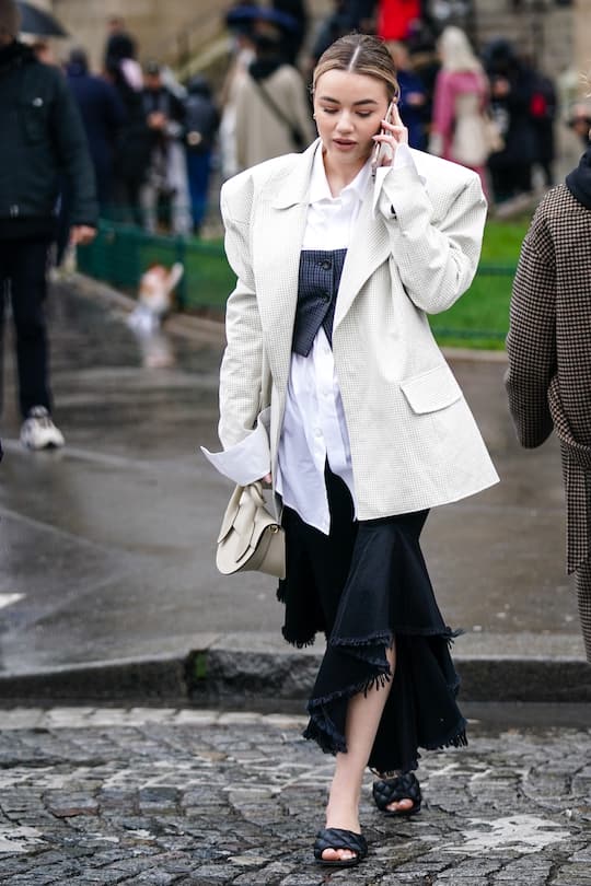 PARIS, FRANCE - FEBRUARY 27: A guest wears a white oversized blazer jacket, a white bag, a black ripped skirt, black quilted shoes, a white shirt, outside Chloe, during Paris Fashion Week - Womenswear Fall/Winter 2020/2021, on February 27, 2020 in Paris, France. (Photo by Edward Berthelot/Getty Images)