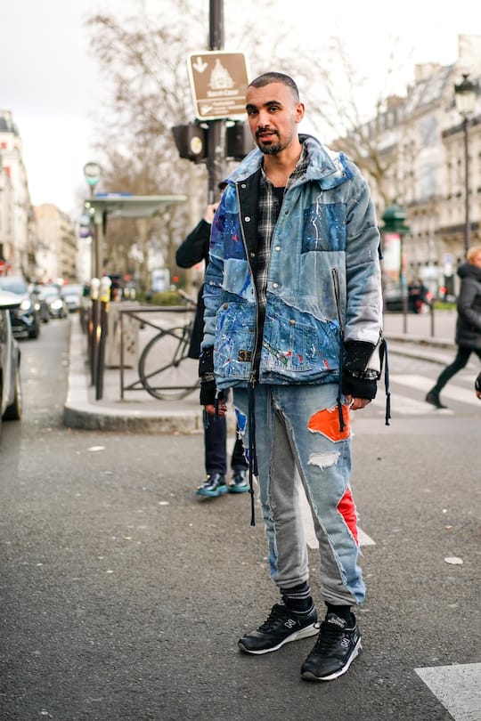 PARIS, FRANCE - JANUARY 19: A guest wears a hooded blue patchwork quilted ripped jacket, a black and white checkered shirt, patched and ripped sport pants, black New Balance sneakers, outside Paul Smith, during Paris Fashion Week - Menswear Fall/Winter 2020-2021 on January 19, 2020 in Paris, France. (Photo by Edward Berthelot/Getty Images)