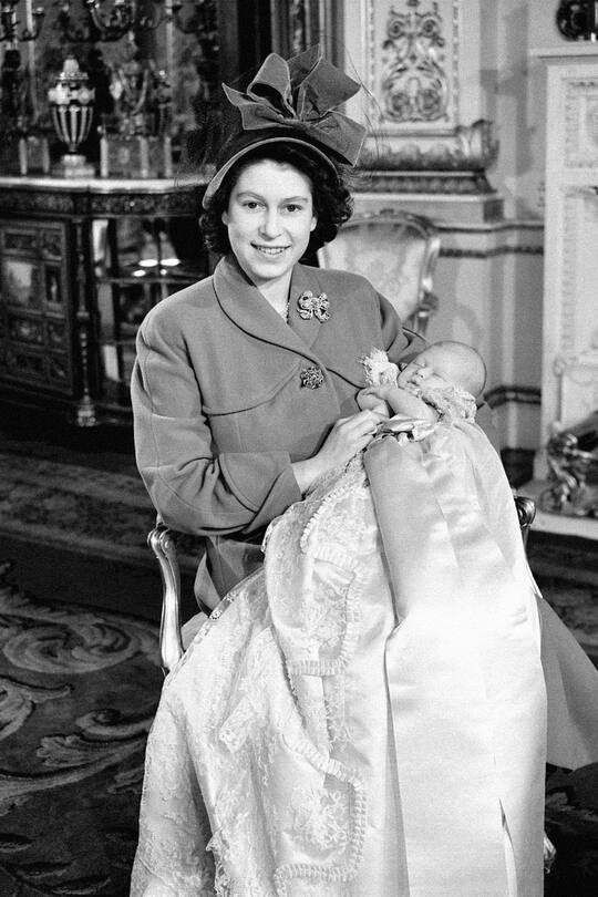 Princess Elizabeth holds her baby son, Prince Charles, after his christening ceremony at Buckingham Palace. (Photo by PA Images via Getty Images)