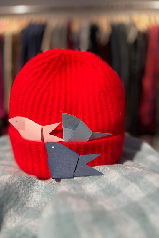 red beanie on a blanket with origami