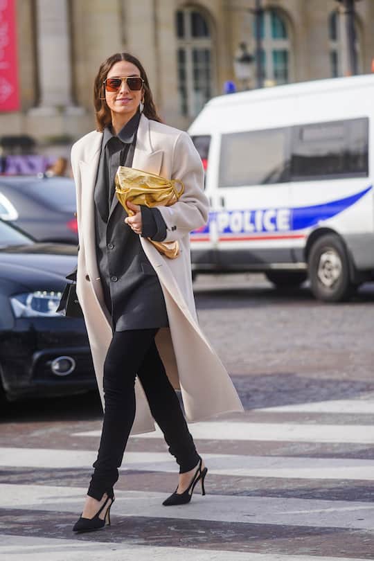 PARIS, FRANCE - MARCH 03: Erika Boldrin wears sunglasses, a white long coat, a gray oversized jacket, a golden puff bag, black pants, pointy shoes, outside Chanel, during Paris Fashion Week - Womenswear Fall/Winter 2020/2021 on March 03, 2020 in Paris, France. (Photo by Edward Berthelot/Getty Images)