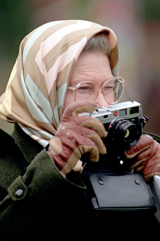 Britain's Queen Elizabeth II uses a Leica camera to take a photograph of her husband, the Duke of Edinburgh, as he competes in the Dressage Section of the Carriage Driving Championships at the Royal Windsor HorseShow. (FOTO: DUKAS/PA PHOTOS)