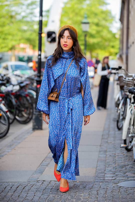 COPENHAGEN, DENMARK - AUGUST 07: Sania Claus Demina is seen wearing hair loop, brown Boyy mini bag, blue dress with slit outside Helmstedt during Copenhagen Fashion Week Spring/Summer 2020 on August 07, 2019 in Copenhagen, Denmark. (Photo by Christian Vierig/Getty Images)