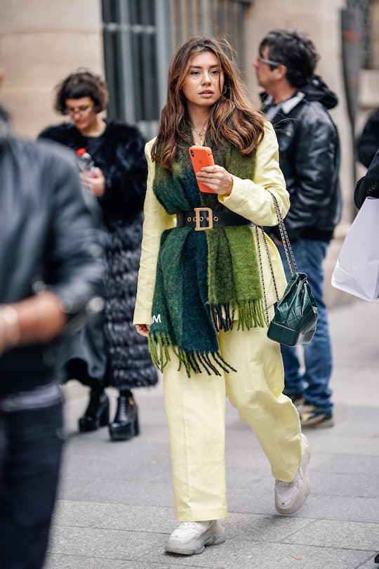 PARIS, FRANCE - MARCH 03: A guest wears a yellow jacket, yellow pants, white sneakers, a green scarf, a Dior belt, a green quilted bag, outside Paul & Joe, during Paris Fashion Week Womenswear Fall/Winter 2019/2020, on March 03, 2019 in Paris, France. (Photo by Edward Berthelot/Getty Images)