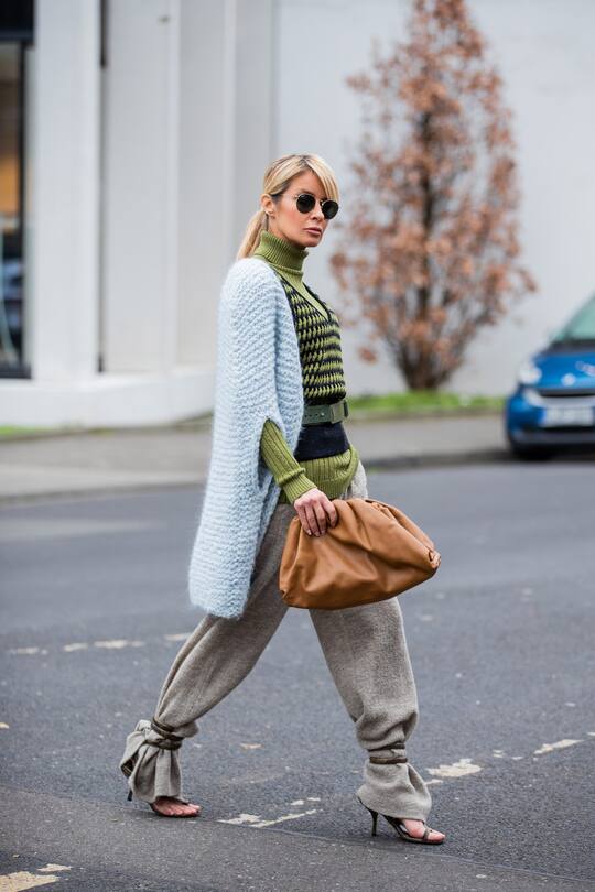 DUSSELDORF, GERMANY - JANUARY 25: Gitta Banko is seen wearing green cashmere ribbed turtleneck, black cashmere top, a light blue handmade sleeveless cardigan, beige pants and green leather belt by Boscana x Gitta Banko, the Pouch bag from Bottega Venetta and python sandals with wrap around straps by Bottega Venetta , black Ray Ban sunglasses on January 25, 2020 in Dusseldorf, Germany. (Photo by Christian Vierig/Getty Images)