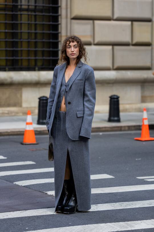 NEW YORK, NEW YORK - SEPTEMBER 13: Katerina Tannenbaum wearing grey blazer, skirt with slit, black boots, bag with animal print outside Peter Do on September 13, 2022 in New York City. (Photo by Christian Vierig/Getty Images)