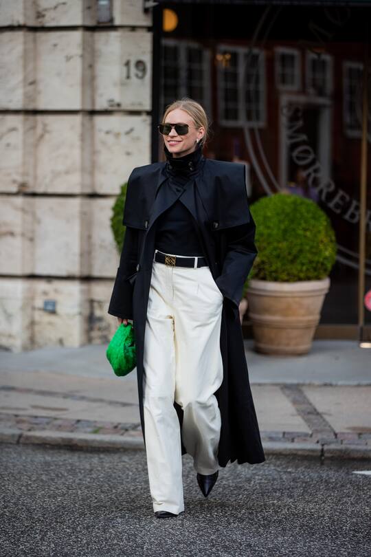 COPENHAGEN, DENMARK - AUGUST 10: Tine Andrea wearing black coat, white pants, green Bottega Veneta bag seen outside The Garment on August 10, 2021 in Copenhagen, Denmark. (Photo by Christian Vierig/Getty Images)