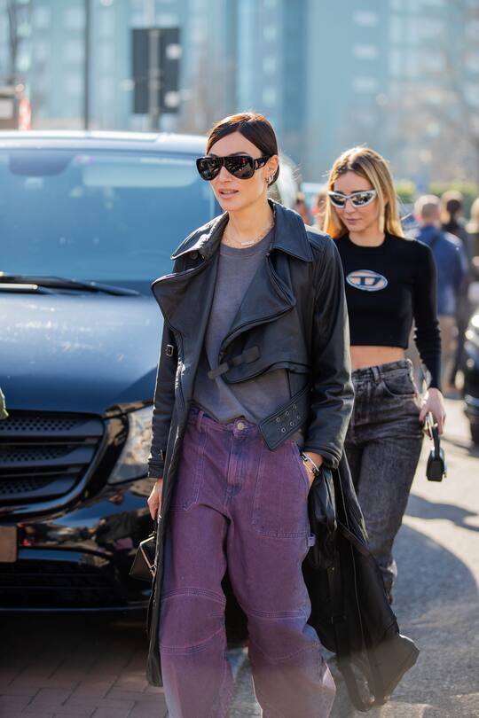 MILAN, ITALY - FEBRUARY 23: Giorgia Tordini wearing black leather coat, purple pants & Chiara Capitani wearing cropped jumper, dark denim jeans, ankle boots seen outside Diesel fashion show during the Milan Fashion Week Fall/Winter 2022/2023 on February 23, 2022 in Milan, Italy. (Photo by Christian Vierig/Getty Images)