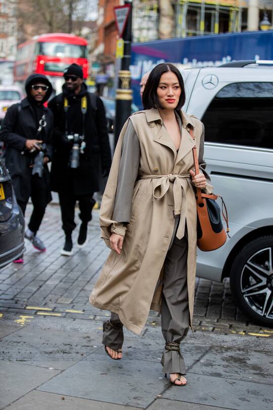 LONDON, ENGLAND - FEBRUARY 17: A guest is seen wearing ripped trench coat, grey blazer and pants, Bottega sandals outside Erdem during London Fashion Week February 2020 on February 17, 2020 in London, England. (Photo by Christian Vierig/Getty Images)