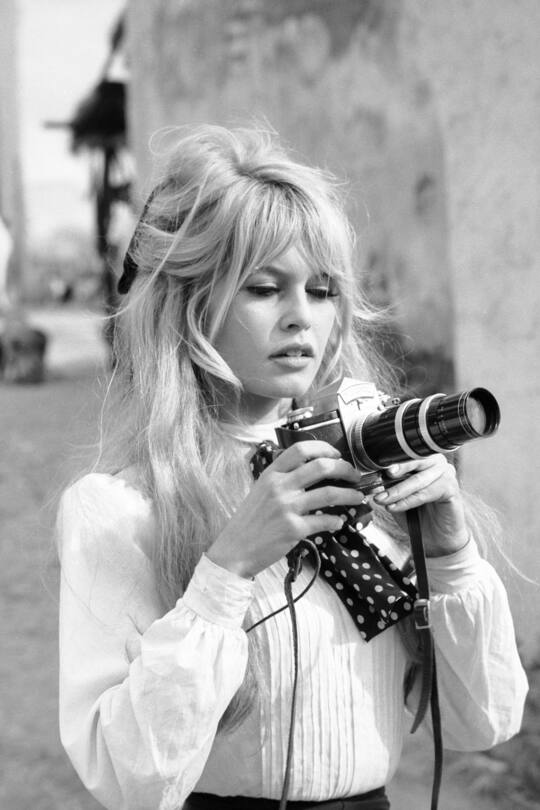 French actress Brigitte Bardot holds a camera during a break in the filming of the movie 'Viva Maria' (directed by Louis Malle), Texcoco, Mexico, February 1965. (Photo by Ralph Crane/The LIFE Picture Collection via Getty Images)