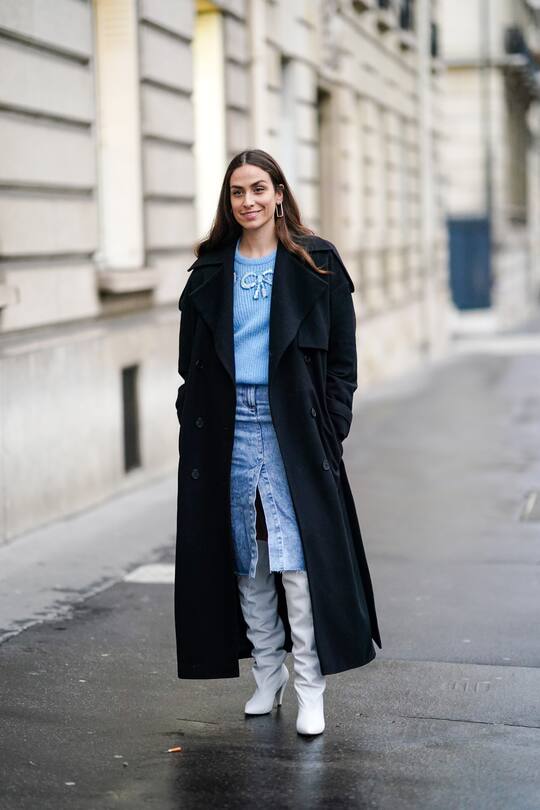 PARIS, FRANCE - FEBRUARY 28: Erika Boldrin wears a dark long coat, a blue pullover, a blue denim skirt, white leather long boots, outside Alessandra Rich, during Paris Fashion Week - Womenswear Fall/Winter 2020/2021, on February 28, 2020 in Paris, France. (Photo by Edward Berthelot/Getty Images)