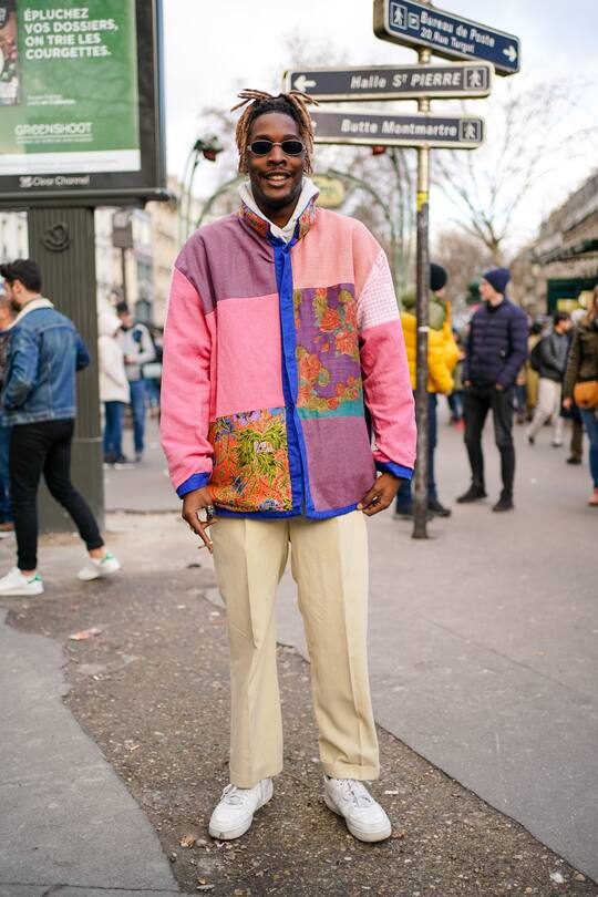 PARIS, FRANCE - JANUARY 19: A guest wears sunglasses, a white hooded sweatshirt, a colorful patchwork jacket, light yellow pants, white Nike sneakers, outside Paul Smith, during Paris Fashion Week - Menswear Fall/Winter 2020-2021 on January 19, 2020 in Paris, France. (Photo by Edward Berthelot/Getty Images)