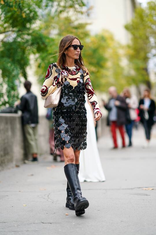 PARIS, FRANCE - SEPTEMBER 26: Chloe Harrouche wears sunglasses, a black shiny sequined dress, a glitter bag, a yellow top with colored printed features, black leather high boots, outside Paco Rabanne, during Paris Fashion Week - Womenswear Spring Summer 2020, on September 26, 2019 in Paris, France. (Photo by Edward Berthelot/Getty Images)