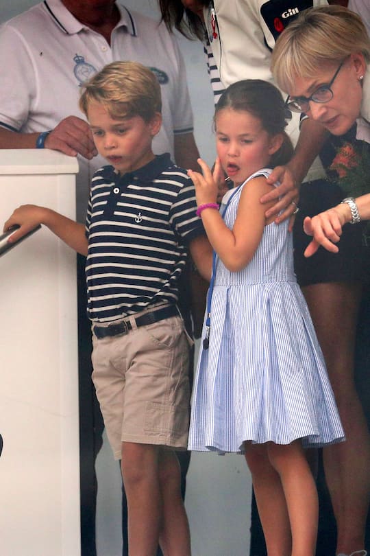COWES, ENGLAND - AUGUST 08: Prince George of Cambridge and Princess Charlotte of Cambridge look through a window at the prize giving after the King's Cup regatta on August 8, 2019 in Cowes, England. (Photo by Andrew Matthews - WPA Pool/Getty Images)