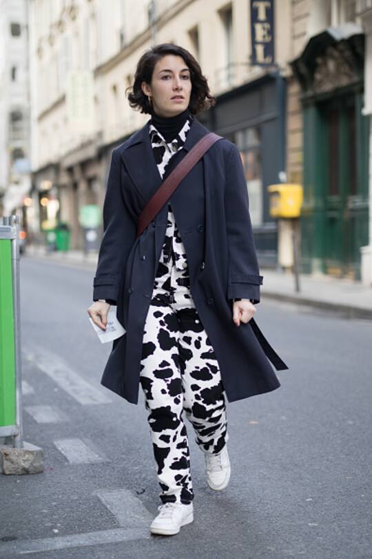 PARIS, FRANCE - MARCH 06: A guest is seen on the street attending Jourden during Paris Women's Fashion Week A/W 2018 wearing a cow print jumpsuit with navy coat on March 6, 2018 in Paris, France. (Photo by Matthew Sperzel/Getty Images)
