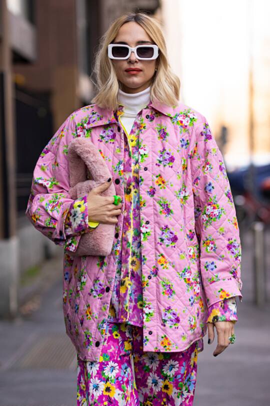 MILAN, ITALY - FEBRUARY 27: Candela Pelizza poses ahead of the MSGM fashion show wearing a pink floral printed sequins shirt, pink floral printed pants and jacket, pink fur bag during the Milan Fashion Week Fall/Winter 2022/2023 on February 27, 2022 in Milan, Italy. (Photo by Claudio Lavenia/Getty Images)