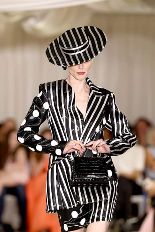 Coco Rocha eröffnet bei Christian Siriano im gepunkteten und gestreiften Kostüm, ergänzt durch einen passenden Fascinator und Kitten Heels. (Photo by Arturo Holmes/Getty Images for Christian Siriano)