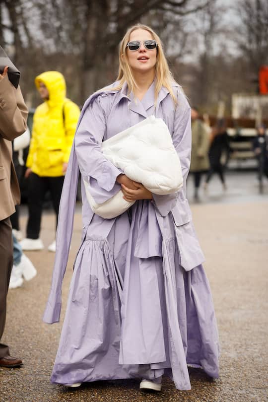 PARIS, FRANCE - FEBRUARY 26: A guest wearing lavender purple coat and white Bottega Veneta oversized clutch outside the Mason Magiela show during the Paris Fashion Week Womenswear Fall/Winter 2020/2021 on February 26, 2020 in Paris, France. (Photo by Hanna Lassen/Getty Images)