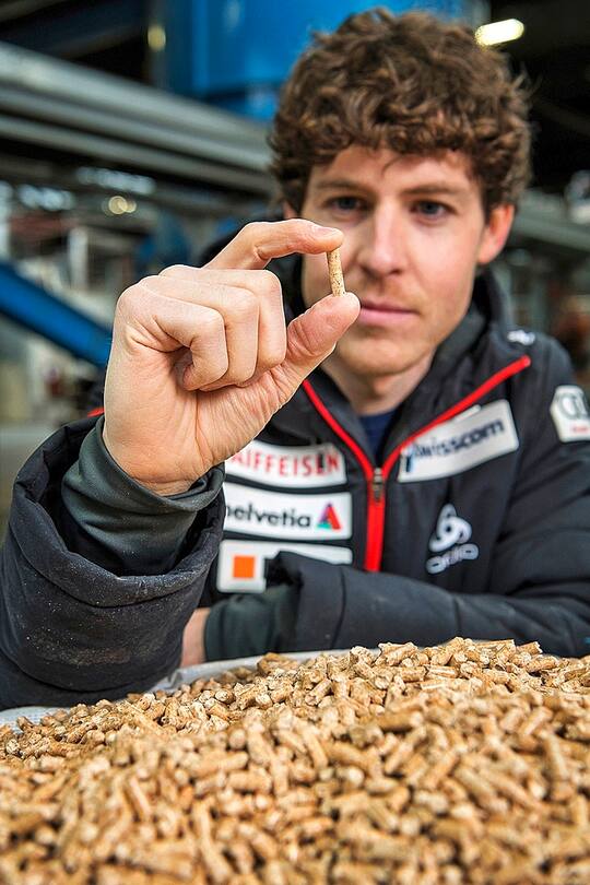 Der Nordisch- Kombinierer Tim Hug mit einem Holzpellet, das aus gepresstem Sägemehl besteht.