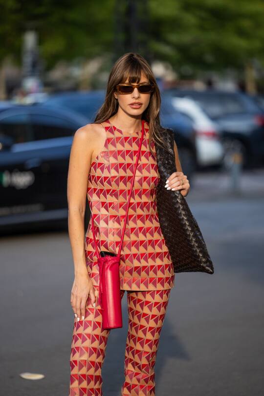 COPENHAGEN, DENMARK - AUGUST 07: A guest wears red beige top, pants, brown bag outside Baum & Pferdgarten during day three of the Copenhagen Fashion Week (CPHFW) SS25 on August 07, 2024 in Copenhagen, Denmark. (Photo by Christian Vierig/Getty Images)
