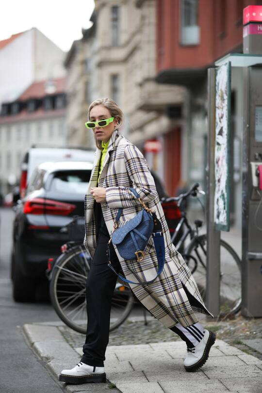 BERLIN, GERMANY - SEPTEMBER 13: Sonia Lyson wearing Dior saddle bag, Dr Martens Jadon boots, Adidas track pants, Edited coat, Edited top and Gucci sunglasses on September 13, 2019 in Berlin, Germany. (Photo by Jeremy Moeller/Getty Images)
