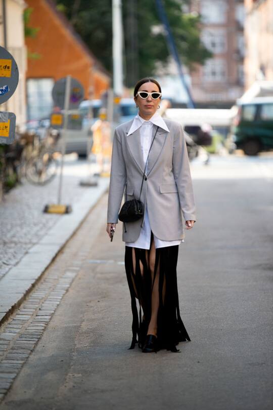 COPENHAGEN, DENMARK - AUGUST 10: Goisa Boy outside Ganni wearing white shirt, grey blaze, black cut in to stripes skirt and black Bottega Veneta bag during Copenhagen fashion week SS21 on August 10, 2020 in Copenhagen, Denmark. (Photo by Raimonda Kulikauskiene/Getty Images)
