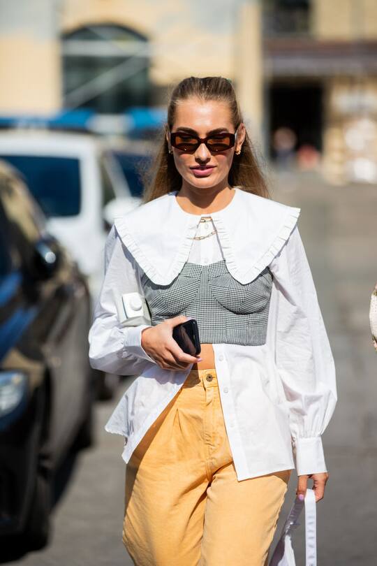COPENHAGEN, DENMARK - AUGUST 11: A guest wearing yellow trousers, white blouse, grey bustier is seen outside Samsøe & Samsøe during Copenhagen Fashion Week Spring/Summer 2021 on August 11, 2020 in Copenhagen, Denmark. (Photo by Christian Vierig/Getty Images)