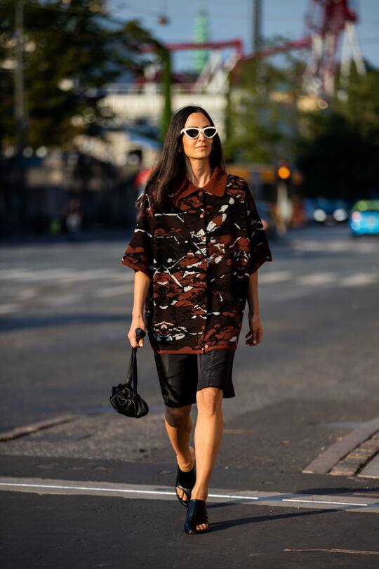 COPENHAGEN, DENMARK - AUGUST 10: Ilenia Toma is seen wearing button shirt with print, shorts, black bag outside soeren le schmidt during Copenhagen Fashion Week Spring Summer 2021 on August 10, 2020 in Copenhagen, Denmark. (Photo by Christian Vierig/Getty Images)