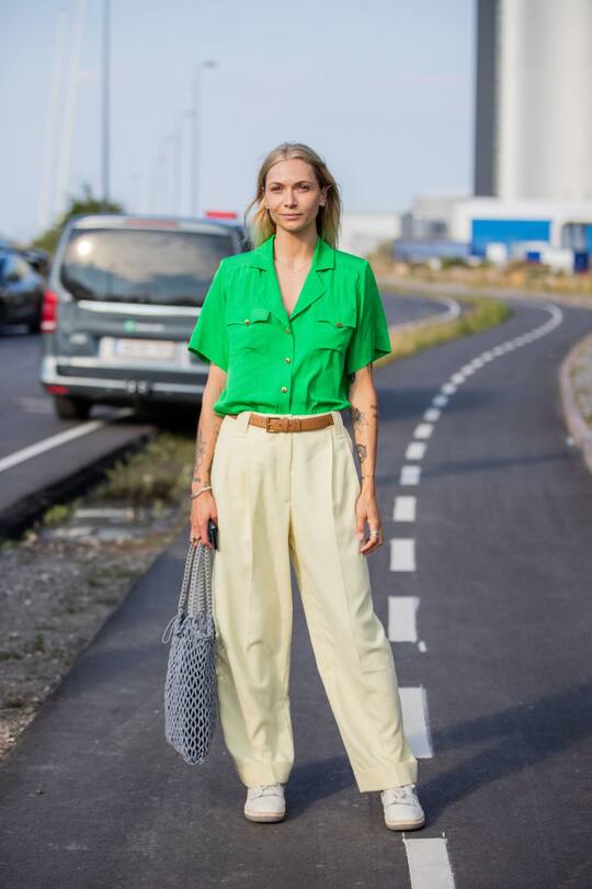 COPENHAGEN, DENMARK - AUGUST 12: A guest is seen wearing beige pants, green top outside Ganni on August 12, 2021 in Copenhagen, Denmark. (Photo by Christian Vierig/Getty Images)