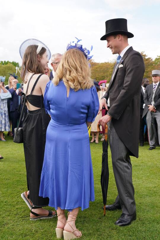 Prinz William unterhält sich mit zwei Gästen.