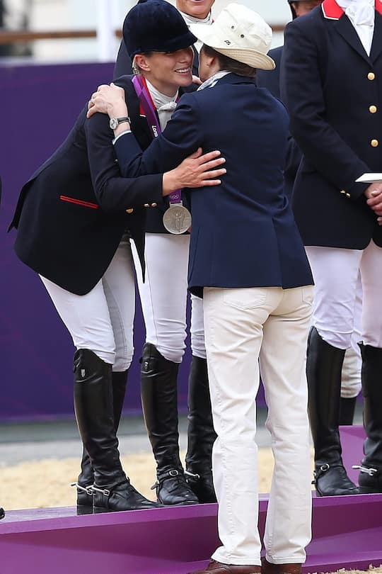 Princess Anne hugs her daughter, Great Britain's Zara Phillips, on the podium with her teammates after winning the silver medal in the team Equestrian of the Eventing competition of the 2012 London Olympics at the Equestrian venue in Greenwich Park, London on July 31, 2012. (Photo By Tommy Hindley/Professional Sport/Popperfoto via Getty Images/Getty Images)