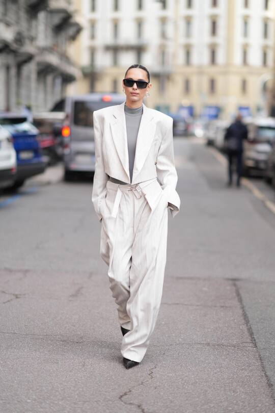MILAN, ITALY - FEBRUARY 28: Candela Pelizza is seen wearing an oversized suit with structured shoulders, a high-neck grey top, wide-leg trousers, black heels, black sunglasses outside the Sportmax show during the Milan Fashion Week Womenswear Fall/Winter 2025/2026 on February 28, 2025 in Milan, Italy. (Photo by Alena Zakirova/Getty Images) Trend Geschichte
