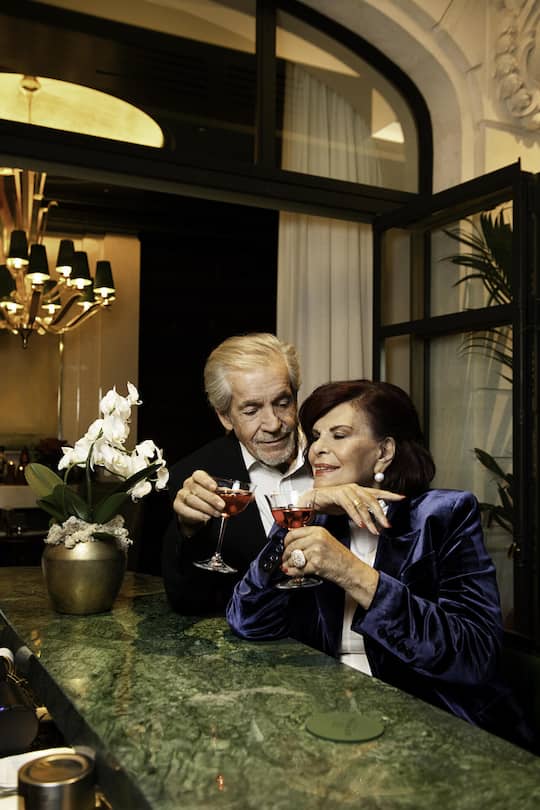 <p>Elizbeth Teissier und Gerhard Hynek kennen sich seit 43 Jahren und sind seit 2011 ein Ehepaar. In der neuen Bar 37 des «The Woodward» in Genf stossen sie auf ihre Liebe an.</p>