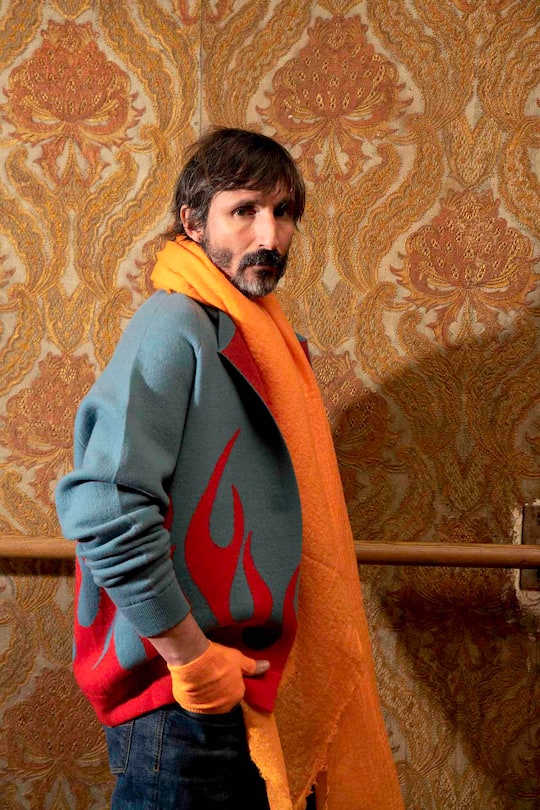 male model posing with yellow scarf and knitted jumper