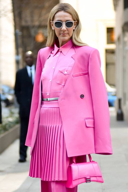 Ganz in Pink: Céline Dion fällt mit ihrem kurzen Plisseerock auf.