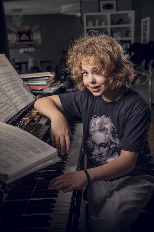 Lucas Chiche an seinem Flügel zu Hause in Genf. Auf seinem T-Shirt das Porträt von einem seiner Idole: Ludwig van Beethoven.