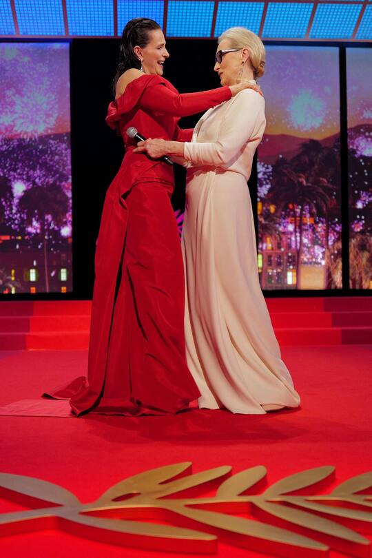 US actress Meryl Streep (R) hugs French actress Juliette Binoche before receiving the Honorary Palme d'Or during the Opening Ceremony at the 77th edition of the Cannes Film Festival in Cannes, southern France, on May 14, 2024. (Photo by Valery HACHE / AFP)