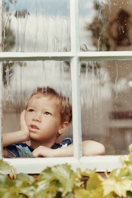 kind schaut dem regen zu