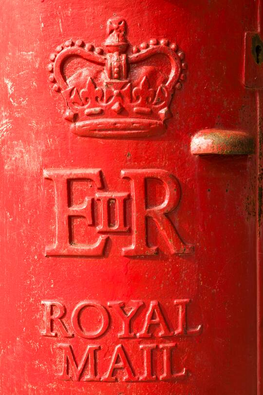 Birmingham, UK - September 1, 2012: Close-up showing the designs on the front of a weathered British post box, featuring the crown logo of the Royal Mail, and the ERII Royal Cypher representing Queen Elizabeth II.
